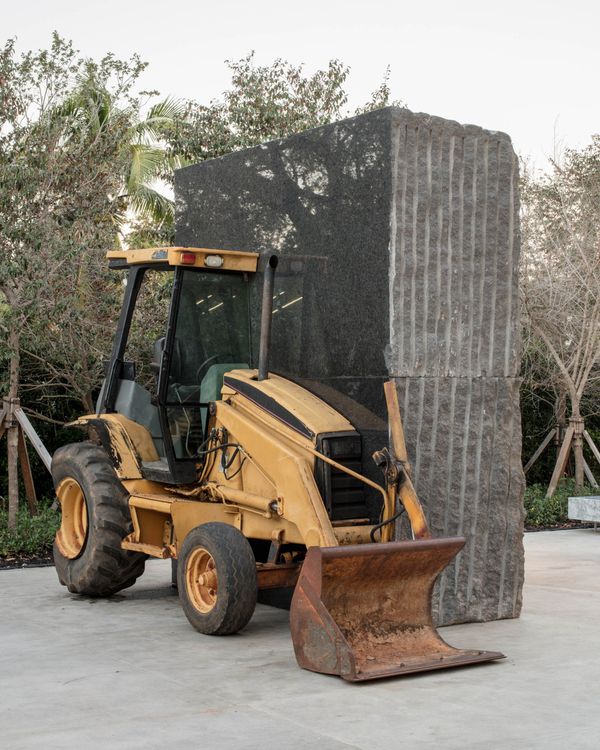 Allora & Calzadilla, Unspecified Promise, 2017, American black granite, 1993 Caterpillar 416 Series loader backhoe. Collection of Institute of Contemporary Art, Miami. Installed in the ICA Miami Sculpture Garden